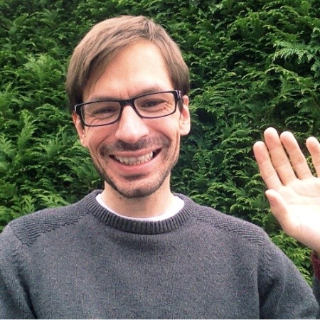 A smiling person waving